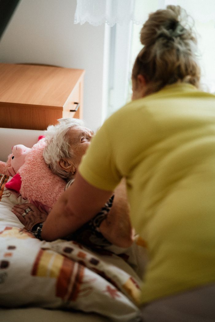 Infirmière au chevet d'une patiente âgée, à son domicile